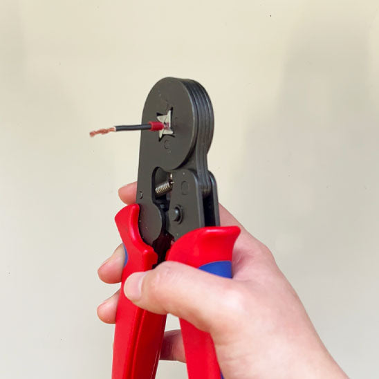 main utilisant pince à sertir