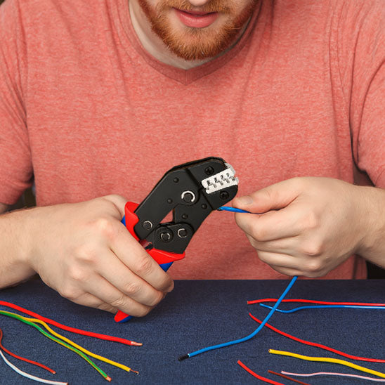 personne sertissant cable avec pince à sertir